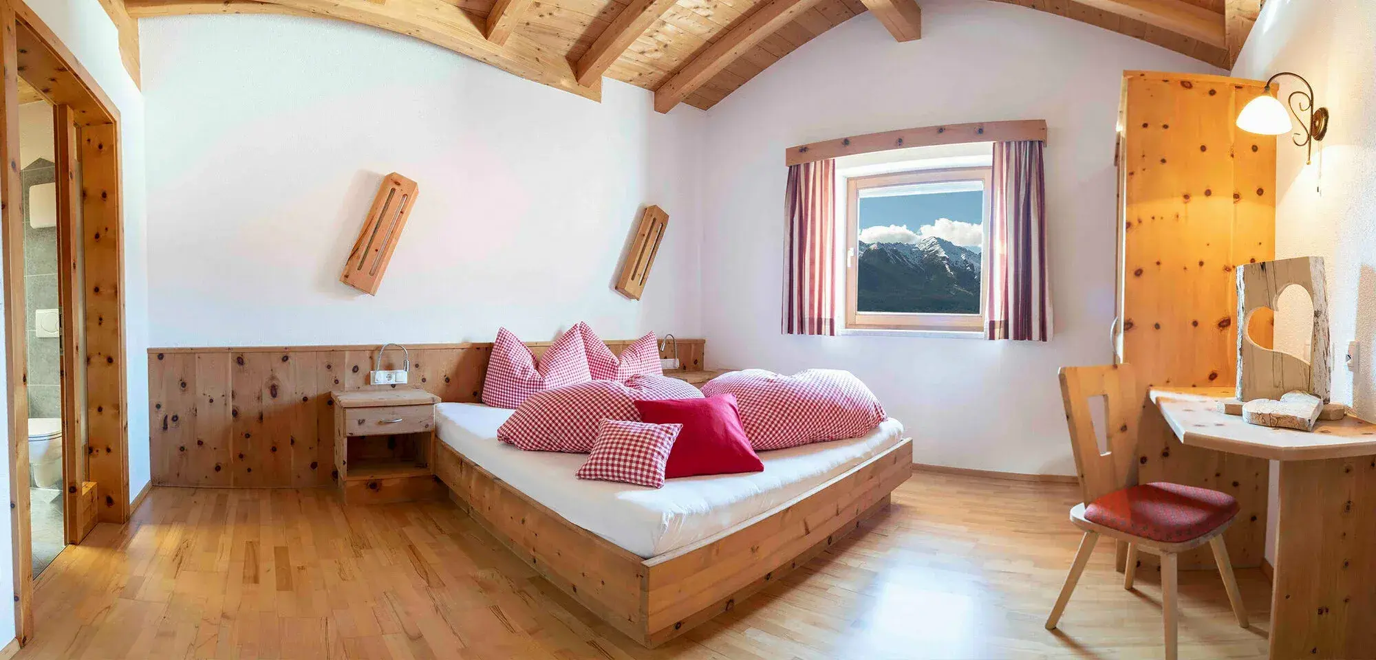 Foto vom Fichtenzimmer mit rot-weiß karierter Bettwäsche